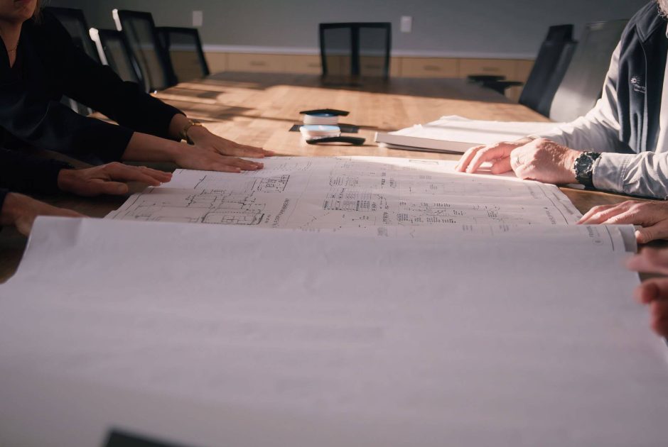 Performance Services' team collaborating around design-build construction plans