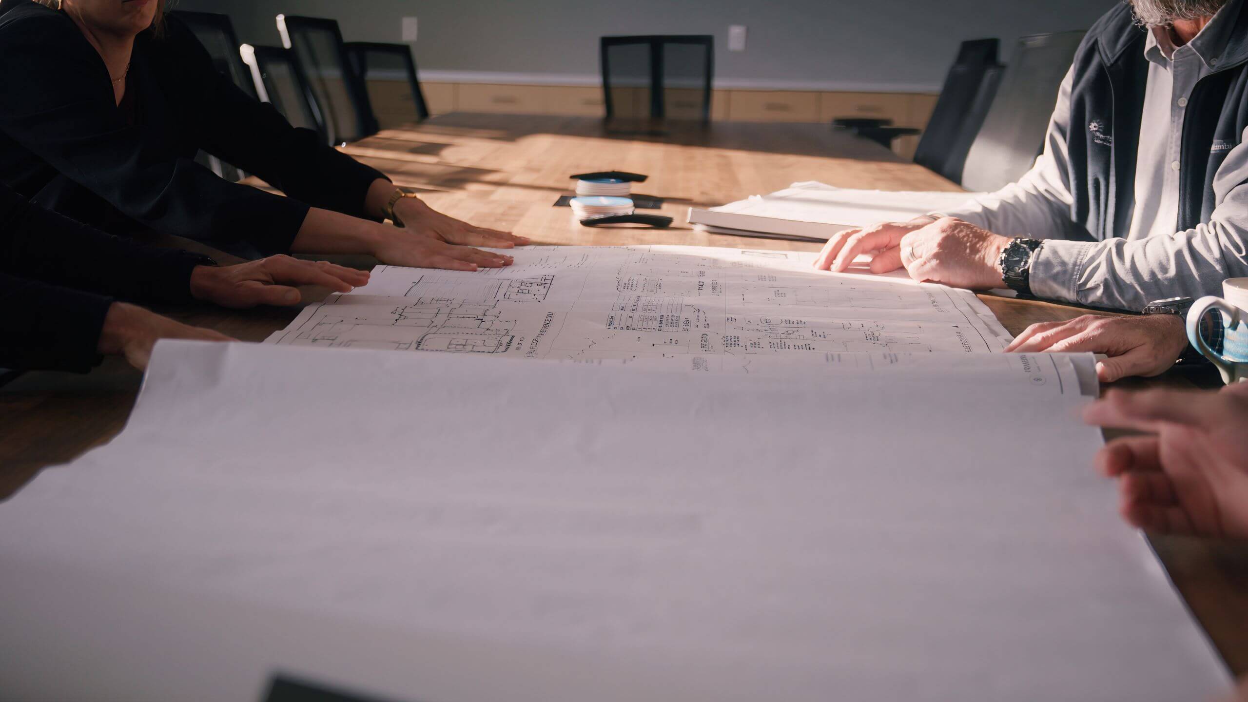 Performance Services' team collaborating around design-build construction plans