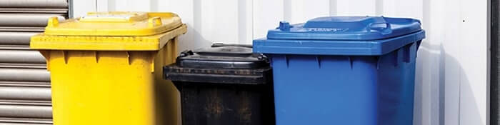 Three colorful recycling bins