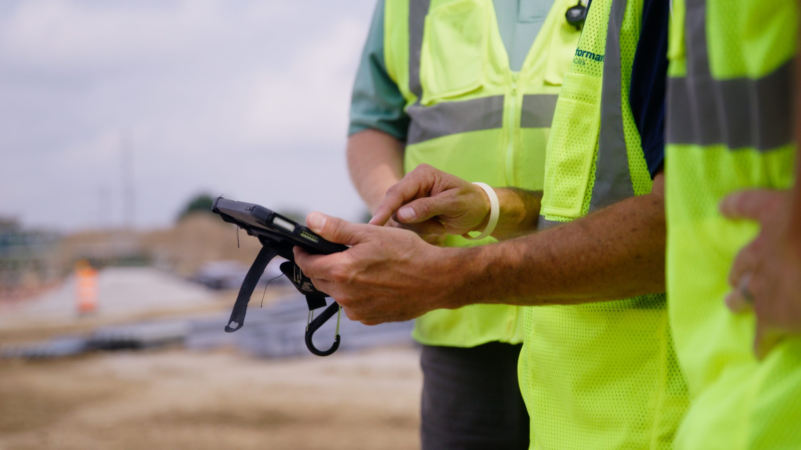 Performance Services employees in PPE reviewing construction documents on a tablet