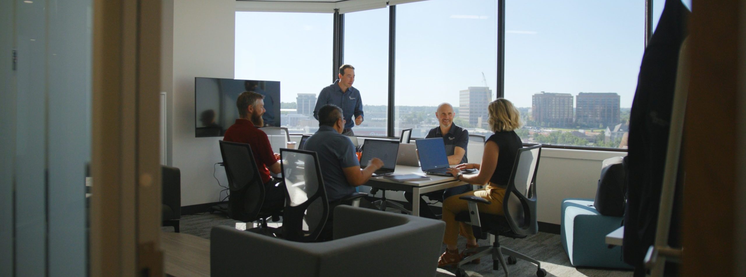 Performance Services Colorado Team members collaborating in a conference room overlooking the city