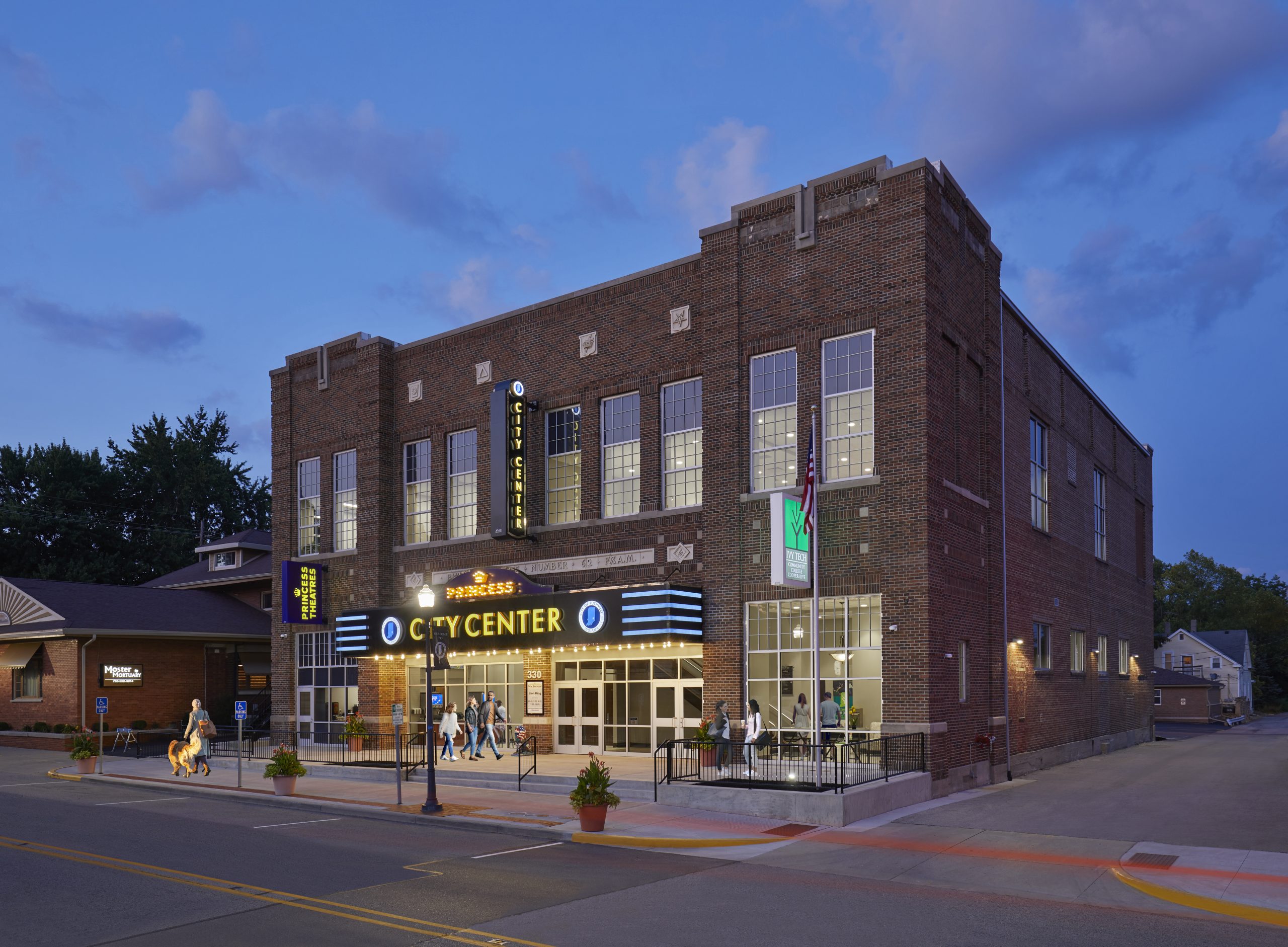 Exterior of the City of Rushville at sunset with people walking by