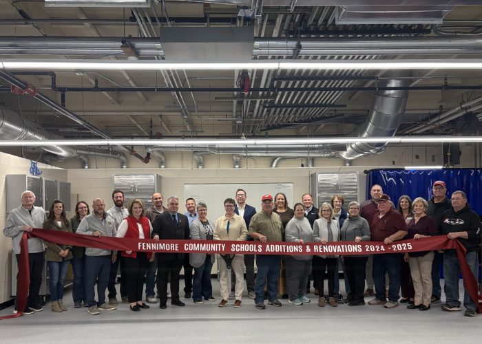 School Board, Superintendent, Referendum Committee and General Contractor posing for a ribbon cutting.