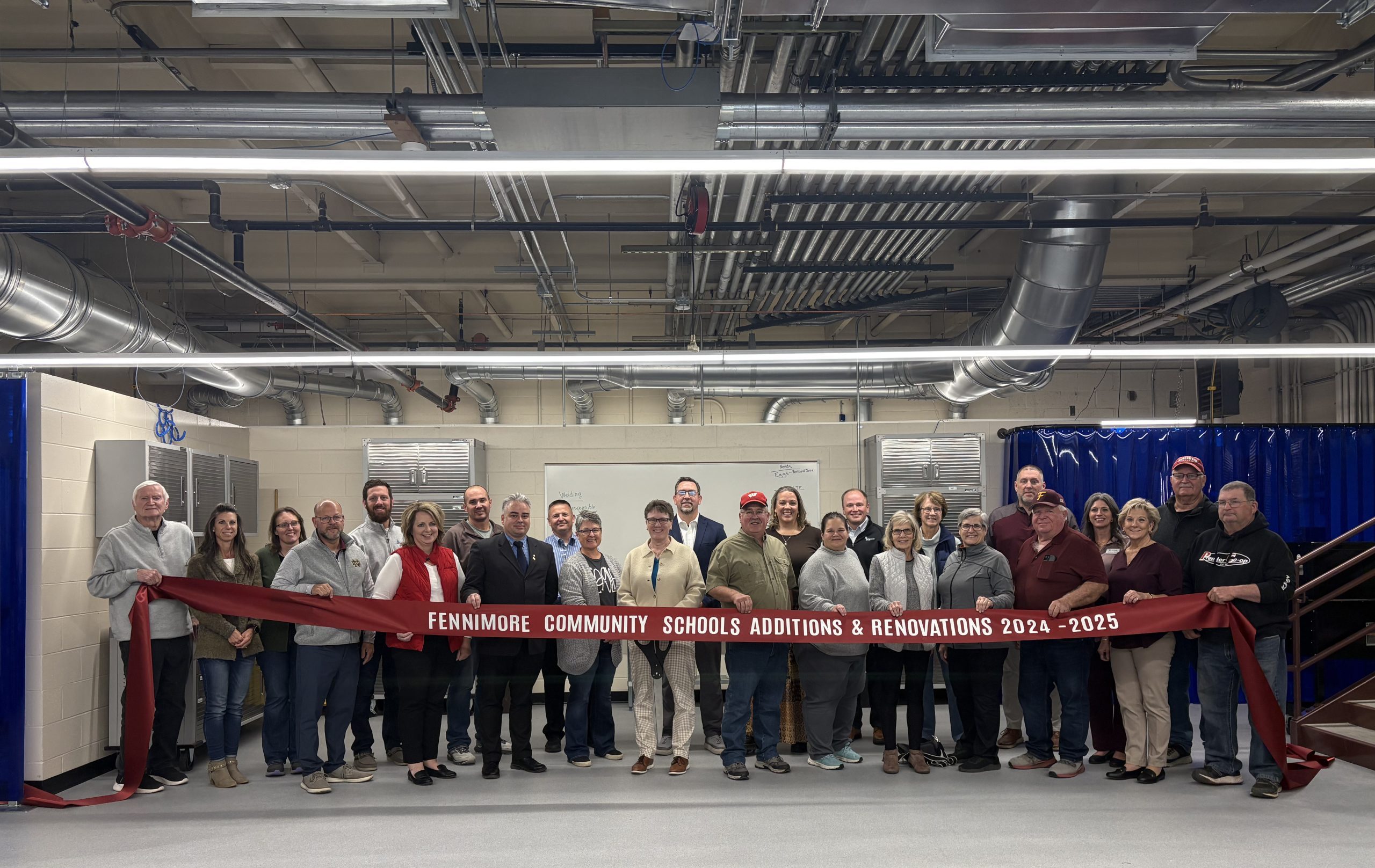 School Board, Superintendent, Referendum Committee and General Contractor posing for a ribbon cutting.
