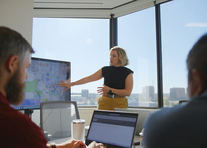 Performance Services Meeting with Clients, Female Pointing to Screen