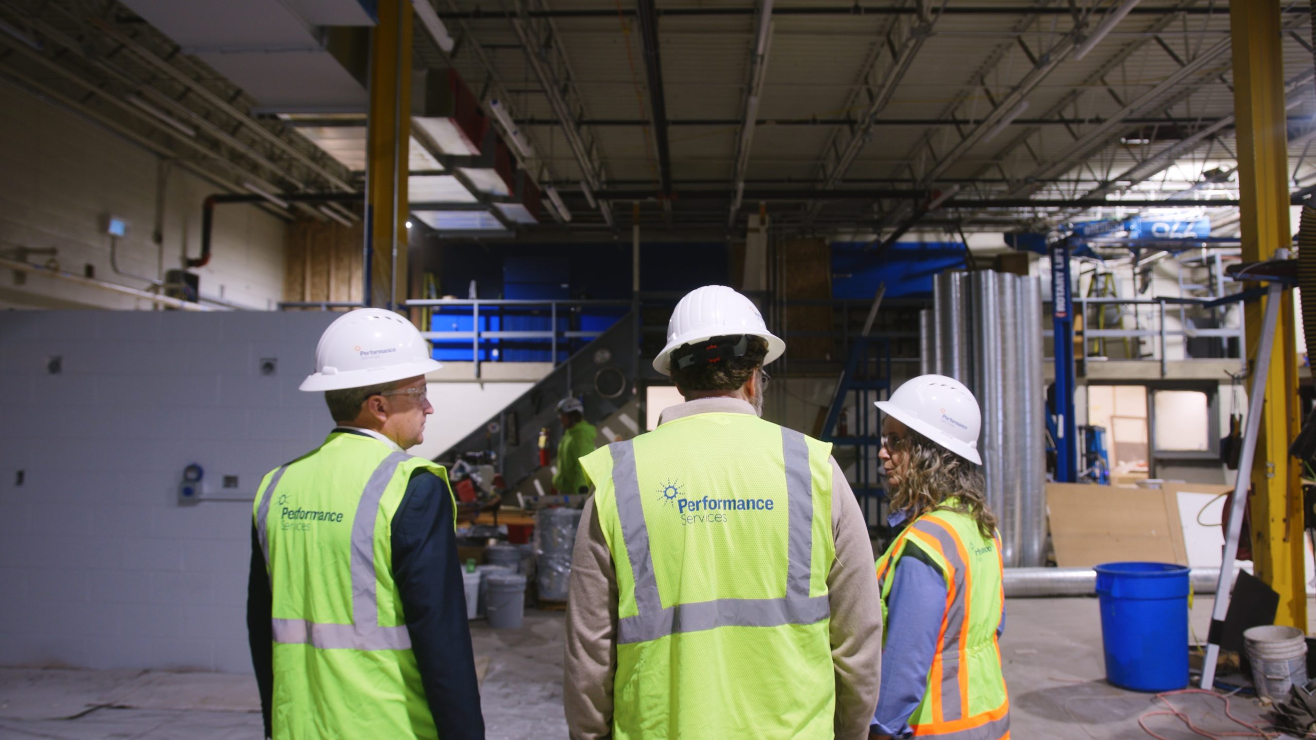 Performance Services team members collaborating at a project design-build site wearing proper PPE
