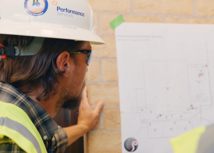 Performances Services team member looking at design-build project wearing proper PPE