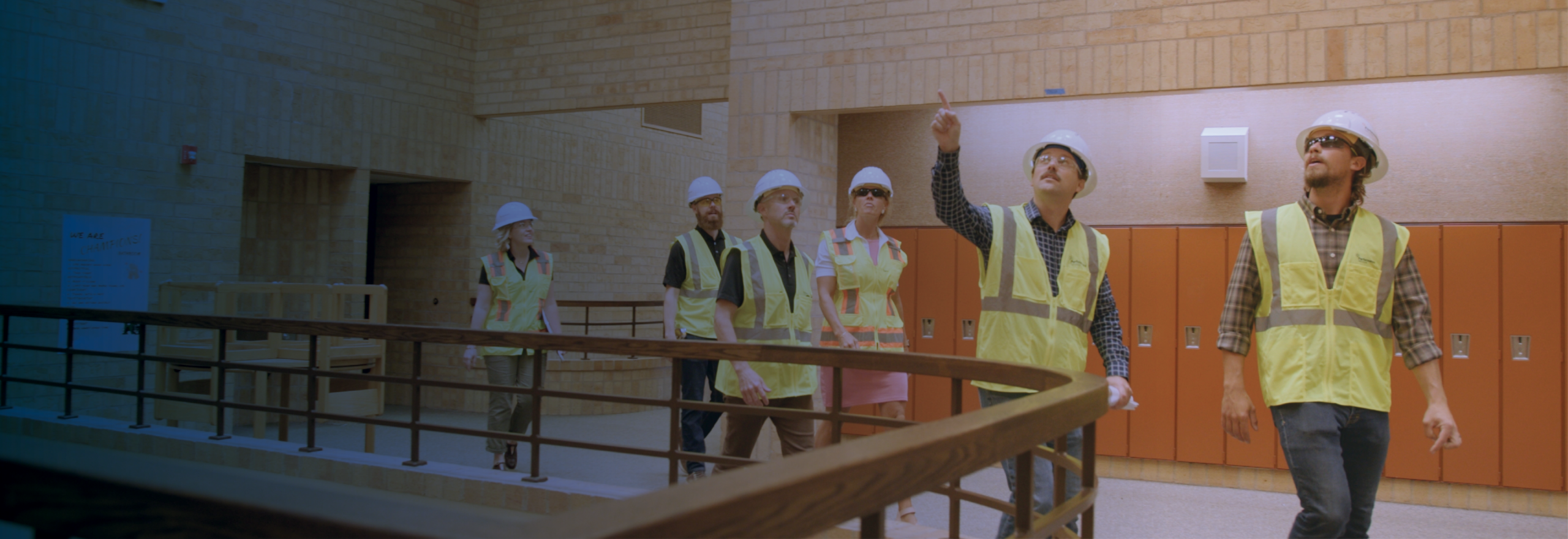 Performance Services team in safety vests and hardhats walking through a school building