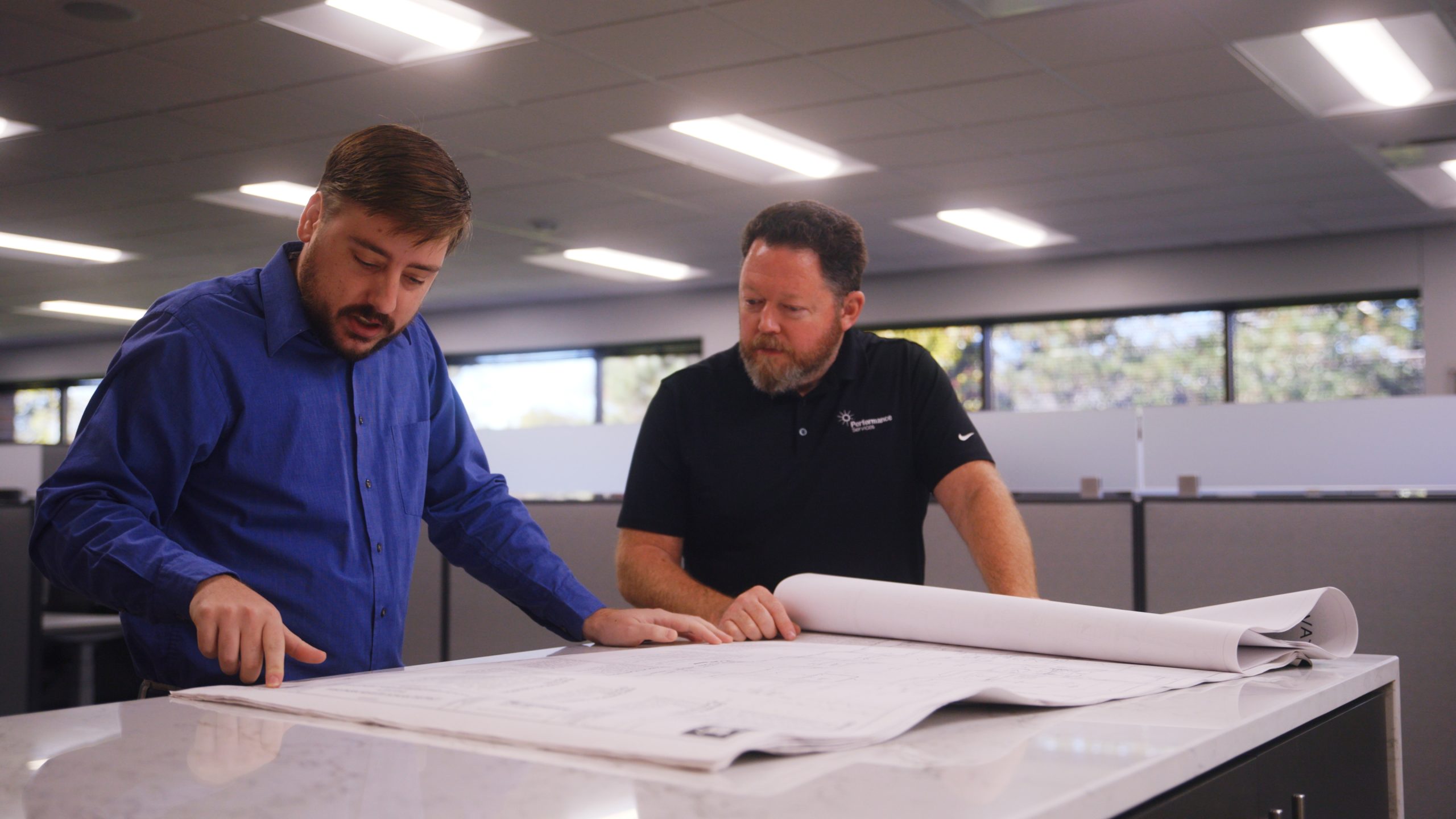Performance Services engineers discussing project plans in an office