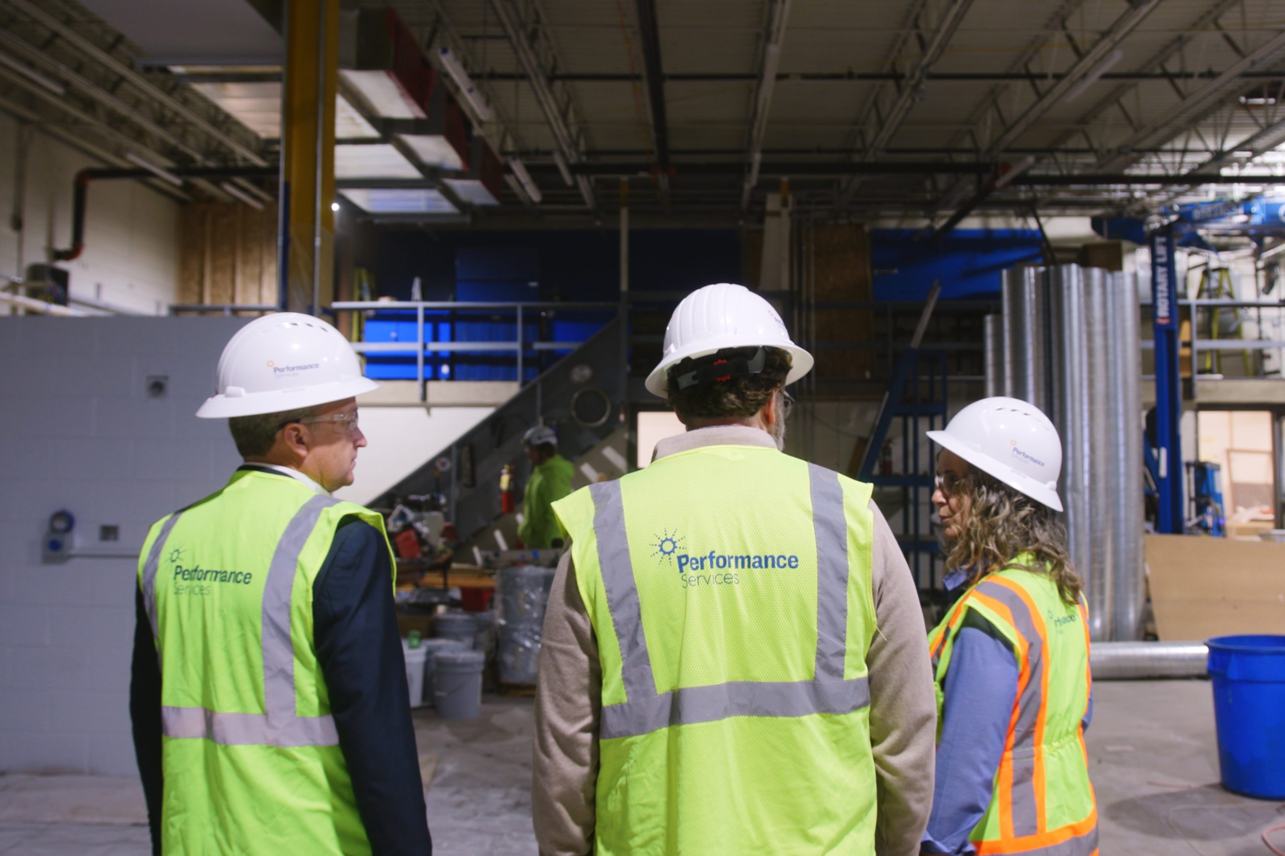 Performance Services team members in proper safety PPE on an active construction site